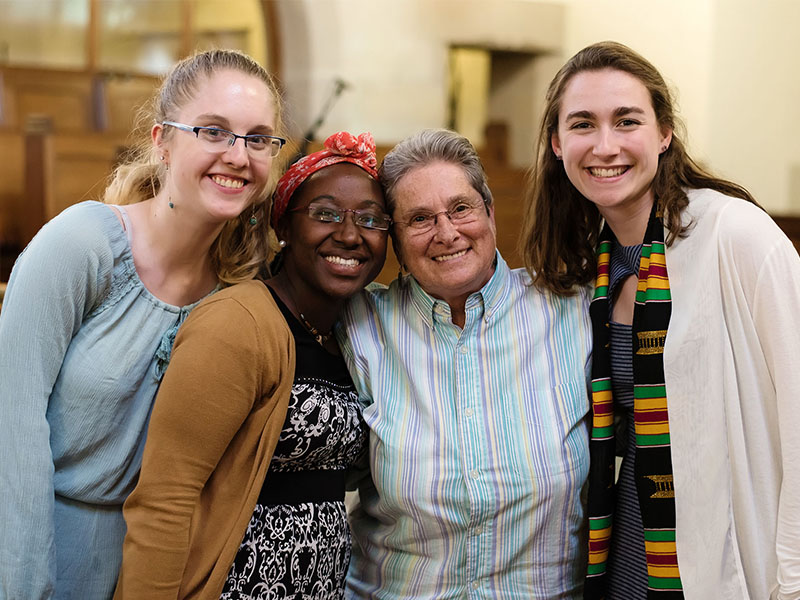 Rev. Kathleen Buckley with three students
