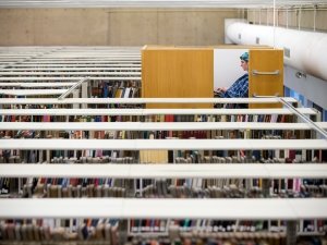 A student sits in a large "treehouse" cubicle elevated among the stacks of books in a library.