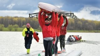 students holding a rowing eight above their heads