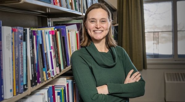 Leah Rohlfsen smiling in front of a bookcase