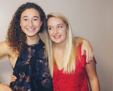 A photo of students Madeleine Nasch and Emma Mellman arm in arm.