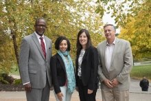 A photo of a group of four St Lawrence alumni smiling with a bunch of trees in the background.
