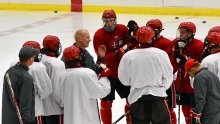 A photo of the hockey team huddled together on the ice. 
