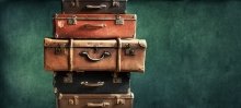 A photo of suitcases stacked on top of one another.
